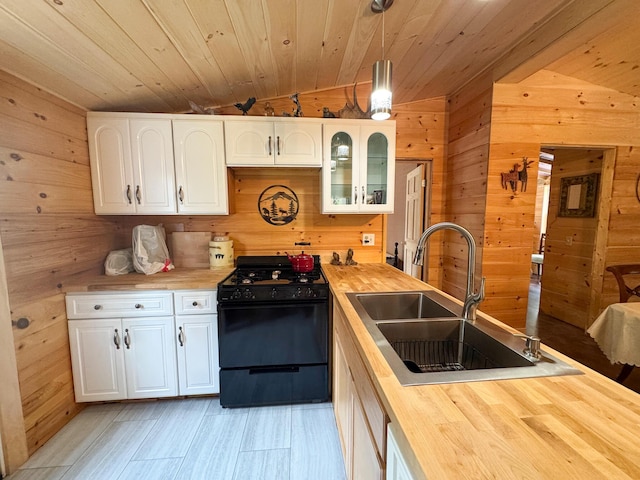 147 Loop Rd, Lincoln, ME 04457 - kitchen with black range with gas cooktop, wooden counters, wood walls, wooden ceiling, and white cabinetry