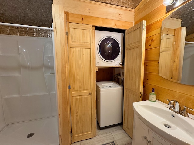 147 Loop Rd, Lincoln, ME 04457 - washroom featuring stacked washer and clothes dryer and wooden walls