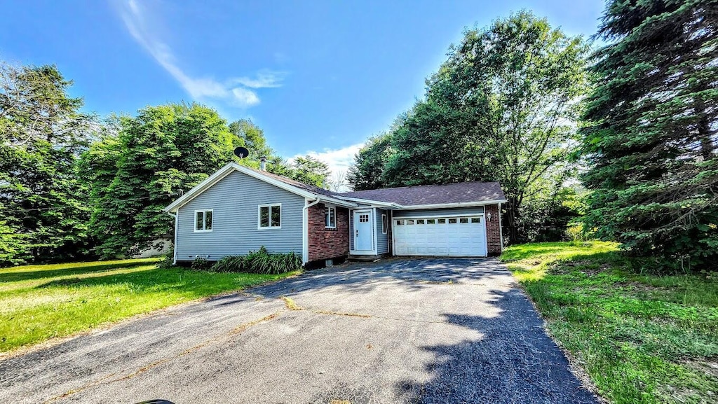 30 Grand Ave, Millinocket, ME 04462 - single story home featuring driveway, a garage, brick siding, and a front yard