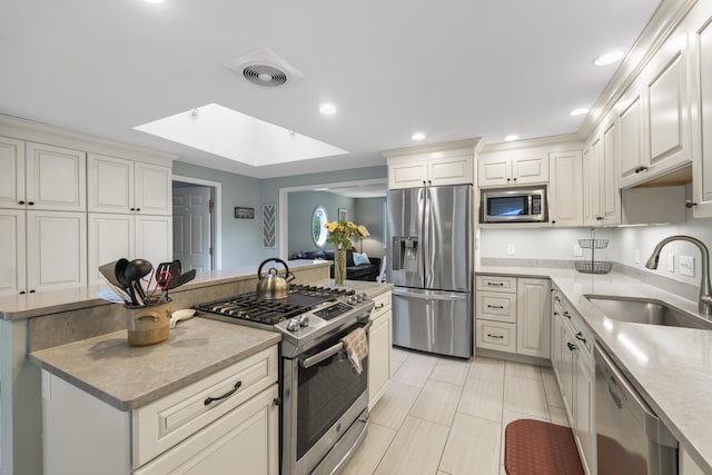 44 Ellen Cir, Yarmouth, ME 04096 - kitchen with appliances with stainless steel finishes, a kitchen island, light countertops, recessed lighting, and white cabinetry
