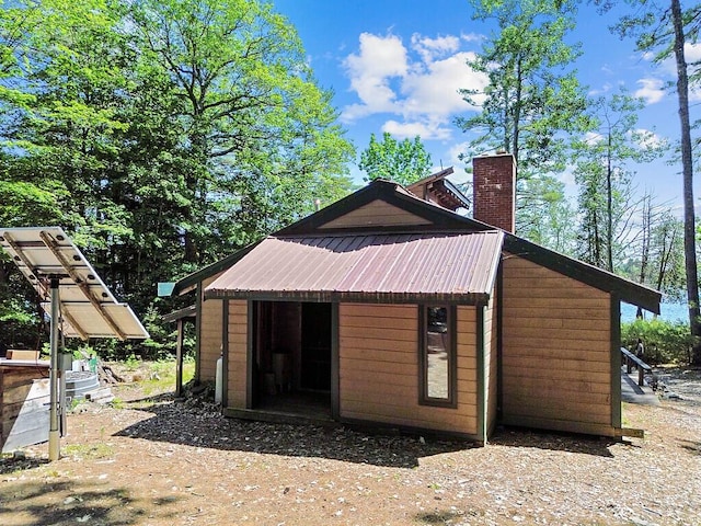 8 Horseshoe Is, Winthrop, ME 04364 - view of side of home featuring a chimney, a metal roof, and an outdoor structure
