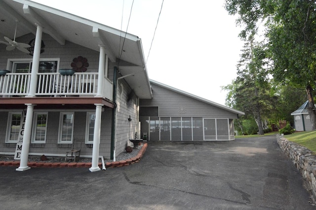 13 S Brook Ln, Eagle Lake, ME 04739 - view of side of home featuring driveway, ceiling fan, a balcony, and an attached garage