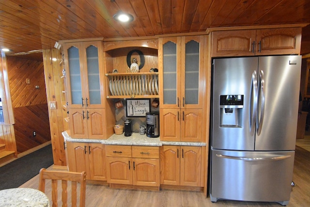 13 S Brook Ln, Eagle Lake, ME 04739 - kitchen featuring stainless steel fridge with ice dispenser, wood ceiling, wood walls, light stone counters, and glass insert cabinets