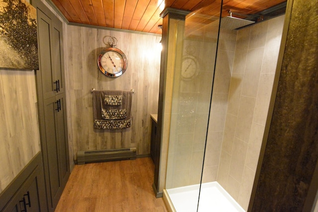 13 S Brook Ln, Eagle Lake, ME 04739 - bathroom featuring baseboard heating, tiled shower, wood finished floors, wooden ceiling, and wooden walls