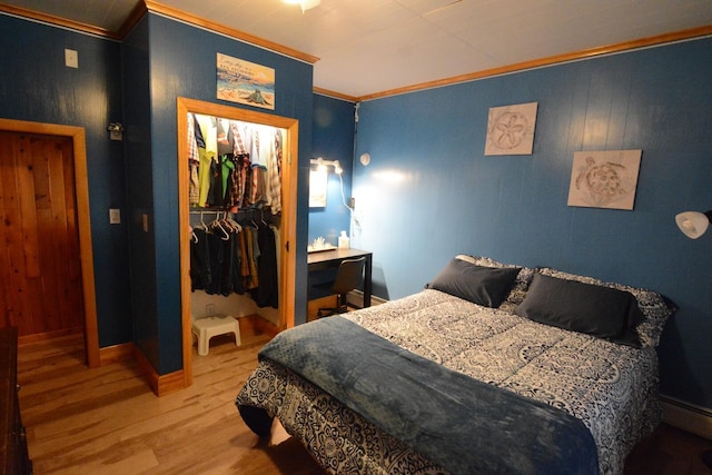 13 S Brook Ln, Eagle Lake, ME 04739 - bedroom with crown molding, wood finished floors, a walk in closet, a closet, and baseboard heating