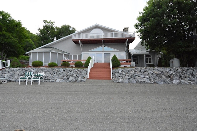 13 S Brook Ln, Eagle Lake, ME 04739 - view of front facade with a balcony, a chimney, and stairs