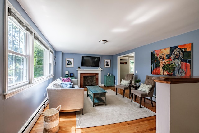 325 Ludlow St, Portland, ME 04102 - living room with a baseboard heating unit, plenty of natural light, a fireplace, and wood finished floors