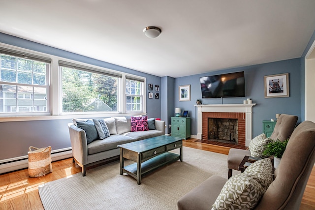 325 Ludlow St, Portland, ME 04102 - living room with plenty of natural light, wood finished floors, a brick fireplace, and a baseboard radiator