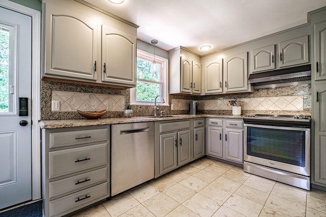 325 Ludlow St, Portland, ME 04102 - kitchen with stainless steel appliances, under cabinet range hood, gray cabinetry, and tasteful backsplash