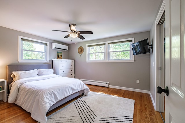 325 Ludlow St, Portland, ME 04102 - bedroom with baseboard heating, a wall unit AC, light wood finished floors, and ceiling fan