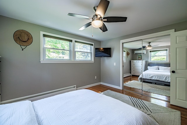 325 Ludlow St, Portland, ME 04102 - bedroom featuring baseboard heating, a wall mounted AC, wood finished floors, a closet, and a baseboard radiator