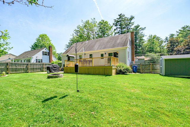 325 Ludlow St, Portland, ME 04102 - fenced backyard with a wooden deck, a fire pit, and an outdoor structure