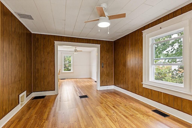 7 James St, Bingham, ME 04920 - spare room featuring healthy amount of natural light, light wood-style flooring, a ceiling fan, and wood walls