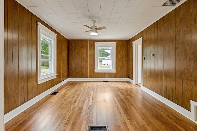 7 James St, Bingham, ME 04920 - empty room with light wood-style flooring, a ceiling fan, and wooden walls