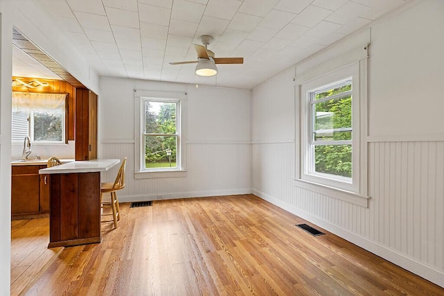 7 James St, Bingham, ME 04920 - dining area featuring light wood finished floors, wainscoting, and a ceiling fan