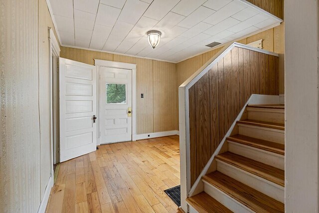 7 James St, Bingham, ME 04920 - foyer featuring light wood-style floors, stairs, wooden walls, and crown molding