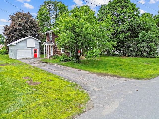 7 James St, Bingham, ME 04920 - view of front of home with an outbuilding, asphalt driveway, a front yard, and a detached garage