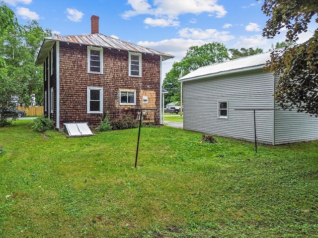 7 James St, Bingham, ME 04920 - rear view of property with a chimney, a lawn, and a metal roof