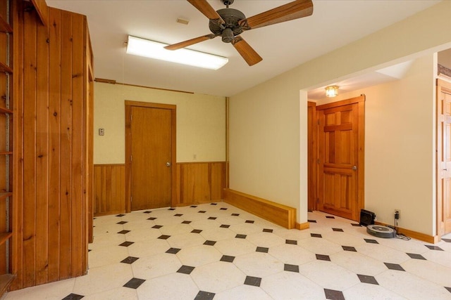 391 Main Rd, Islesboro, ME 04848 - unfurnished room featuring light floors, a ceiling fan, wainscoting, and wood walls
