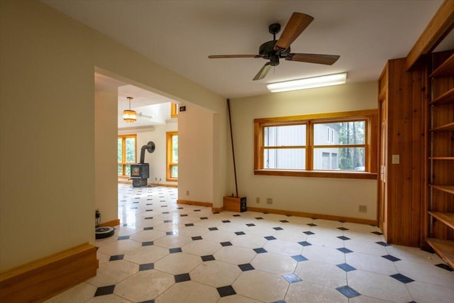 391 Main Rd, Islesboro, ME 04848 - unfurnished room featuring a wood stove, plenty of natural light, a ceiling fan, and light floors