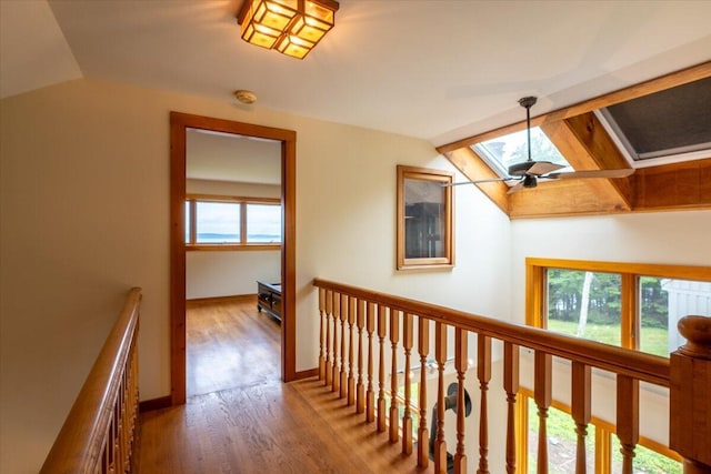 391 Main Rd, Islesboro, ME 04848 - hallway featuring a skylight, lofted ceiling, an upstairs landing, healthy amount of natural light, and wood finished floors