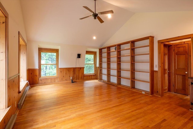 391 Main Rd, Islesboro, ME 04848 - unfurnished living room featuring light wood-type flooring, a wainscoted wall, ceiling fan, high vaulted ceiling, and wooden walls