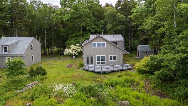 391 Main Rd, Islesboro, ME 04848 - back of property with a wooden deck, a storage shed, a wooded view, and a yard