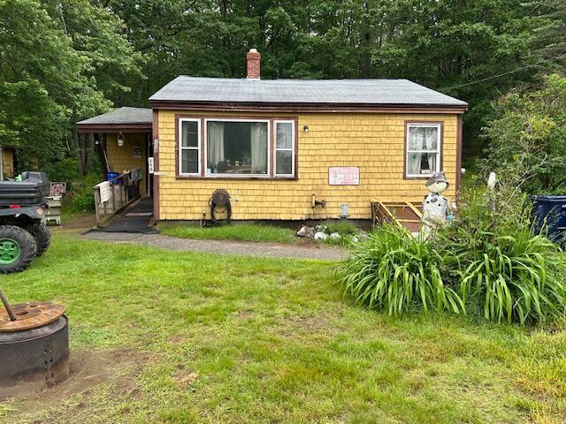 258 Guinea Rd, Biddeford, ME 04005 - bungalow-style house featuring a front yard, a chimney, and a forest view