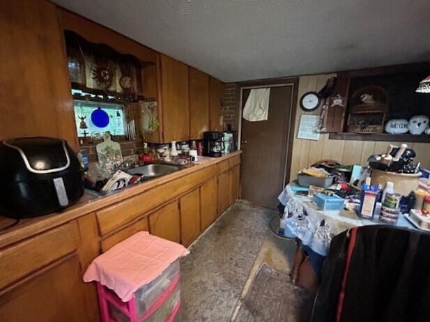258 Guinea Rd, Biddeford, ME 04005 - kitchen featuring brown cabinets, light countertops, and wood walls