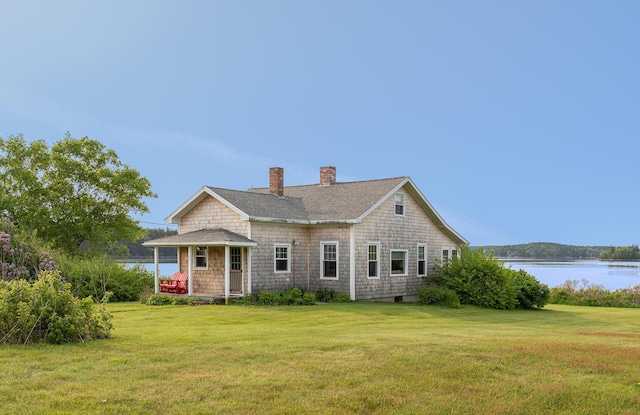 122 Isle Of Springs Rd, Boothbay, ME 04537 - shingle-style home featuring a chimney, a front yard, a water view, and roof with shingles