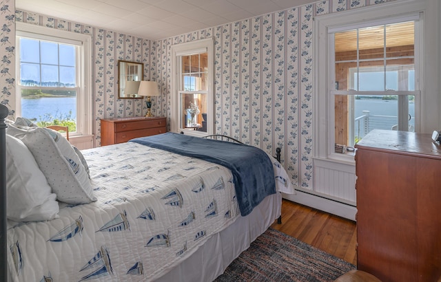 122 Isle Of Springs Rd, Boothbay, ME 04537 - bedroom with wallpapered walls, wood finished floors, baseboard heating, and a water view