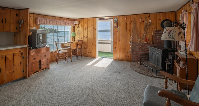 122 Isle Of Springs Rd, Boothbay, ME 04537 - living area with carpet flooring, wooden walls, and a wood stove