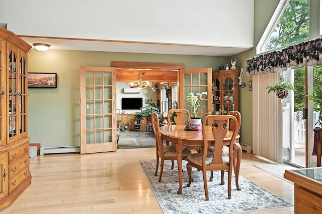 146 Lone Indian Trl, Augusta, ME 04330 - dining area with a chandelier, a baseboard radiator, a high ceiling, light wood-type flooring, and french doors