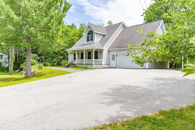 26 Spruce St, Bucksport, ME 04416 - cape cod home featuring covered porch, asphalt driveway, a garage, roof with shingles, and a front lawn