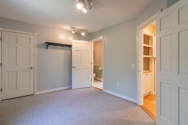 26 Spruce St, Bucksport, ME 04416 - unfurnished bedroom featuring connected bathroom, light carpet, baseboard heating, and rail lighting