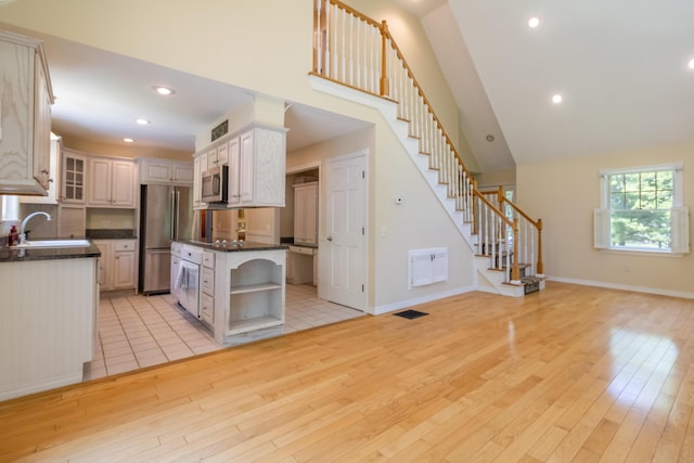 26 Spruce St, Bucksport, ME 04416 - kitchen featuring stainless steel appliances, open shelves, light wood finished floors, recessed lighting, and glass insert cabinets