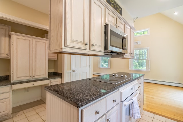 26 Spruce St, Bucksport, ME 04416 - kitchen featuring white oven, black electric stovetop, stainless steel microwave, light tile patterned floors, and plenty of natural light