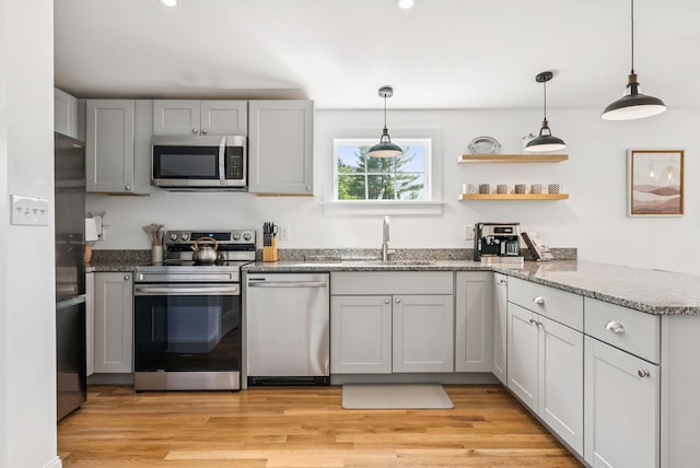 10 Burnell Dr, Yarmouth, ME 04096 - kitchen featuring stainless steel appliances, decorative light fixtures, stone countertops, light wood-type flooring, and open shelves