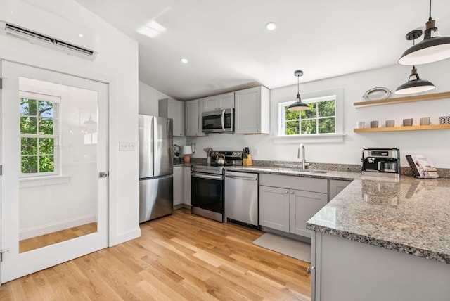 10 Burnell Dr, Yarmouth, ME 04096 - kitchen featuring stainless steel appliances, gray cabinetry, a wall mounted AC, pendant lighting, and light wood finished floors
