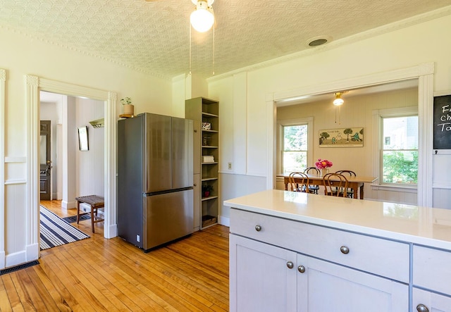 21 Elm St, Belfast, ME 04915 - kitchen with freestanding refrigerator, light wood-style flooring, light countertops, open shelves, and an ornate ceiling