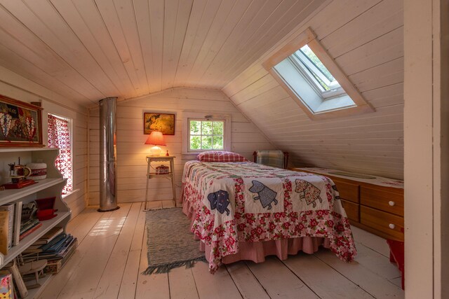 13 Gross Neck Rd, Waldoboro, ME 04572 - bedroom featuring a skylight, vaulted ceiling, wooden ceiling, light wood-type flooring, and wood walls