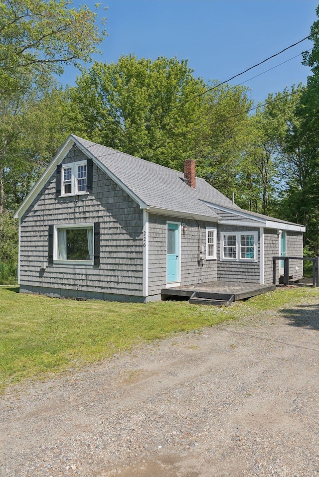 226 Seal Harbor Rd, Saint George, ME 04859 - view of front of property with a chimney, a wooden deck, a front yard, roof with shingles, and dirt driveway