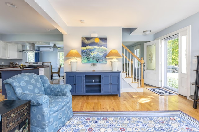 86 Allison Ave, Portland, ME 04103 - living area with light wood finished floors, stairs, ceiling fan, and a wall unit AC