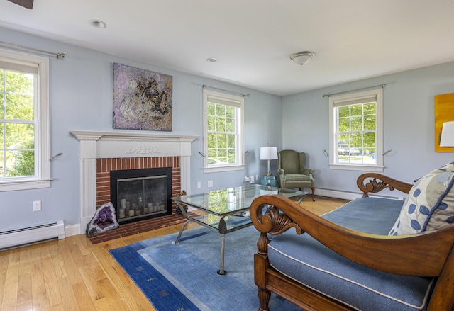 86 Allison Ave, Portland, ME 04103 - living area with a baseboard heating unit, plenty of natural light, wood finished floors, and a fireplace