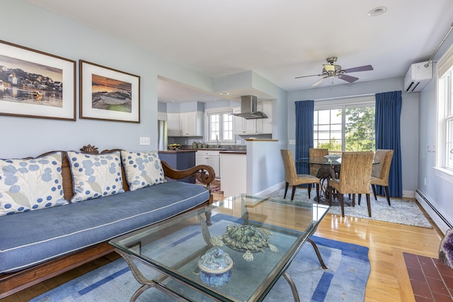 86 Allison Ave, Portland, ME 04103 - living room with a wall mounted air conditioner, baseboard heating, light wood-style flooring, and a ceiling fan