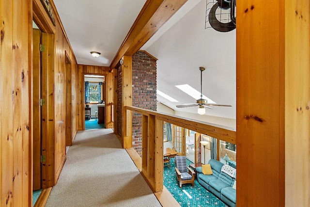 176 Perkins Beach Rd, Wayne, ME 04284 - hallway featuring light carpet, wood walls, lofted ceiling, and a skylight
