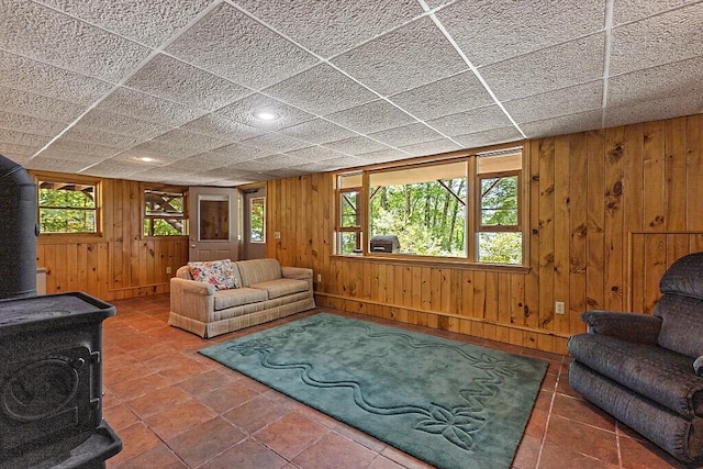 176 Perkins Beach Rd, Wayne, ME 04284 - tiled living area with a wood stove and wooden walls