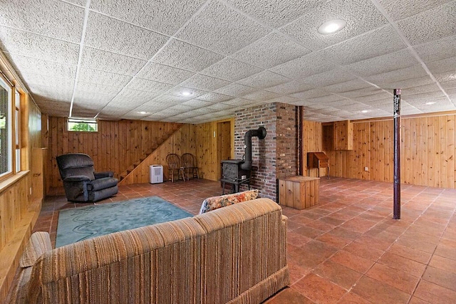 176 Perkins Beach Rd, Wayne, ME 04284 - living room featuring wood walls, a wood stove, and a drop ceiling