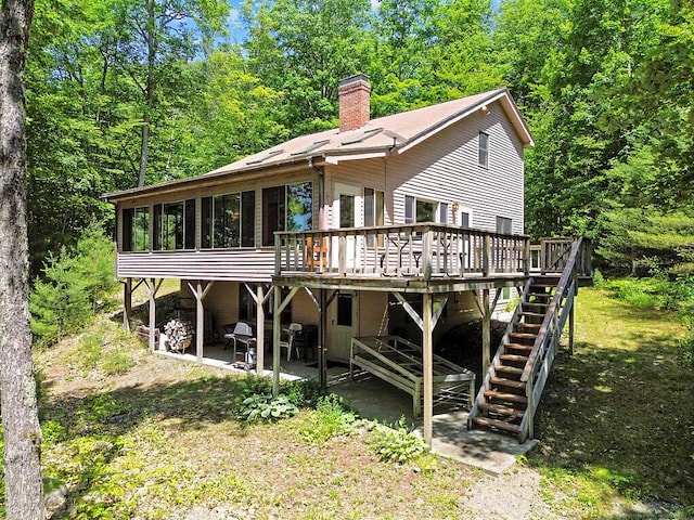 176 Perkins Beach Rd, Wayne, ME 04284 - back of house featuring a chimney, a wooden deck, a patio, a sunroom, and stairway