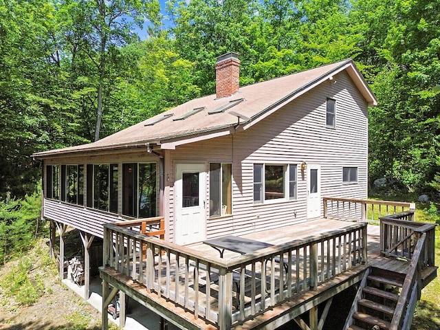 176 Perkins Beach Rd, Wayne, ME 04284 - back of property with a chimney, a wooden deck, and a sunroom